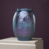 Decorative purple porcelain vase with textured surface on a neutral pedestal against a dark background