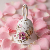 Decorative ceramic bell with floral and butterfly designs on pink petals