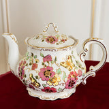 Decorative teapot with floral patterns on a red surface