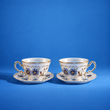 Set of two Zsolnay Tea cups and saucers with the blue and gold cornflower pattern on vibrant blue backdrop