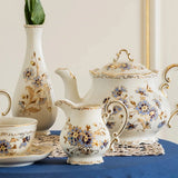 Tea set on a table with decorative wall lights and framed pictures in a room.
