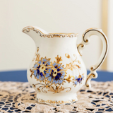 Decorative creamer with floral patterns on a textured surface