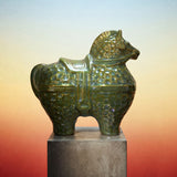 Green ceramic horse sculpture on a pedestal with a gradient background