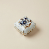 Decorative ceramic box with floral design on a beige background