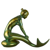 Gold and green mermaid figurine on a white background
