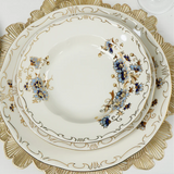 Decorative dinner plate with floral patterns and gold trim on a white background