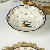 Decorative ceramic bowl with phoenix design on a white tablecloth.