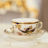 Decorative teacup with gold and blue accents on a matching saucer.