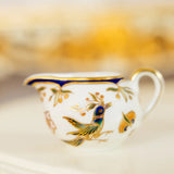 Decorative teacup with bird design on a blurred background