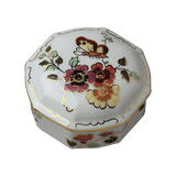 Zsolnay Butterfly hand-painted porcelain octagonal bonbonniere with lid, featuring pink and yellow floral motifs, a butterfly, and gold accents, isolated on a transparent background.
