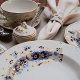 Close-up of Zsolnay Cornflower porcelain plate with hand-painted blue flowers and 18K gold.